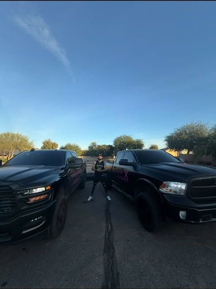 Vaquero X owner standing between two branded RAM trucks